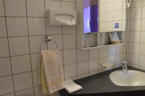 a bathroom with a sink and a towel at Hotel Garni Rösslipost in Unteriberg