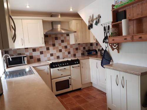 a kitchen with white cabinets and a stove top oven at 6 Seatown, Lossiemouth in Lossiemouth