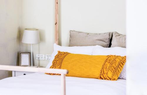a bedroom with a bed with a yellow pillow at The Roof in Kefar Blum