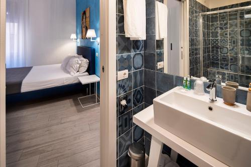 Un baño con lavabo y una cama en una habitación. en IstayinToledo Luxury Guest House, en Nápoles