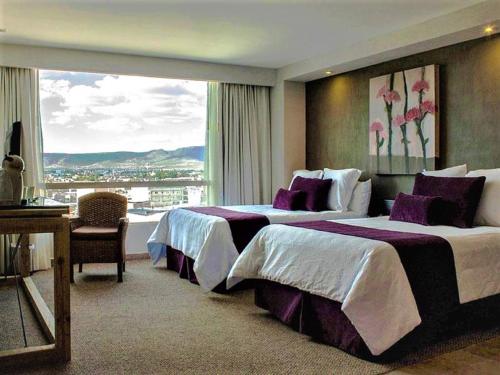 a hotel room with two beds and a large window at NEhotel Nueva Estancia in León