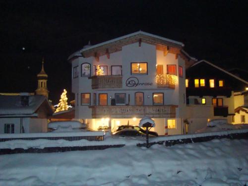 a large white building with a christmas tree in front of it at alpenrose hotel-garni in Gerlos