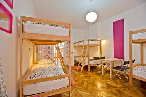 a room with bunk beds and a table and chairs at Centrum House Hostel in Braşov