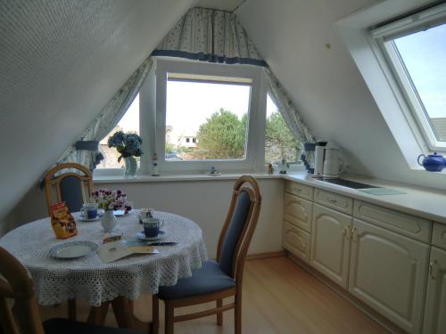 eine Küche mit einem Tisch und einem Fenster in der Unterkunft Fewo Jutta Bönisch in List