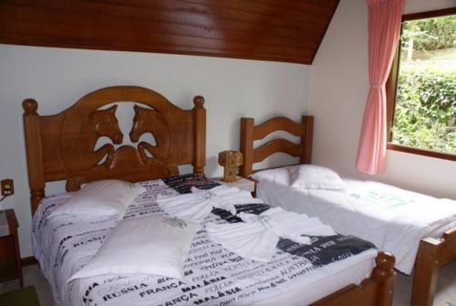 A bed or beds in a room at Pousada Recanto das Flores
