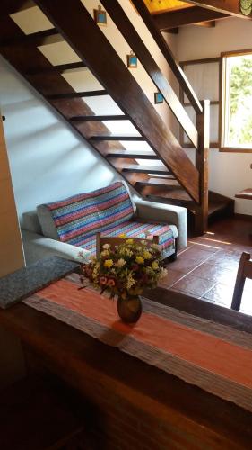 a vase of flowers on a table with stairs at Chalés Lauterbrunnen in Monte Verde