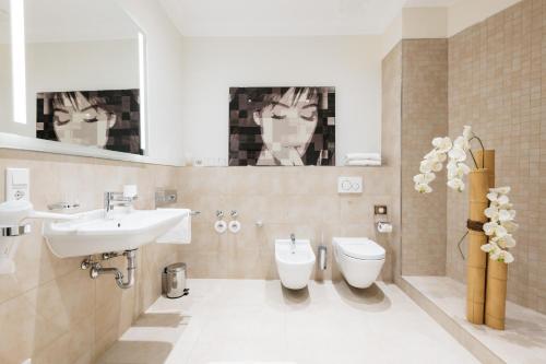 a bathroom with a sink and a toilet at Osteiner Hof by The Apartment Suite in Mainz