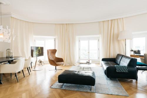 マインツにあるOsteiner Hof by The Apartment Suiteのリビングルーム(黒いソファ、テーブル付)