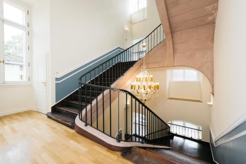 a staircase in a home with a chandelier at Osteiner Hof by The Apartment Suite in Mainz