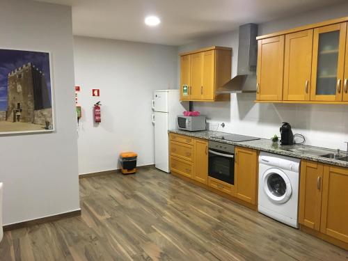 a kitchen with wooden cabinets and a washing machine at Apartamento da Seara "Douro" in Lamego