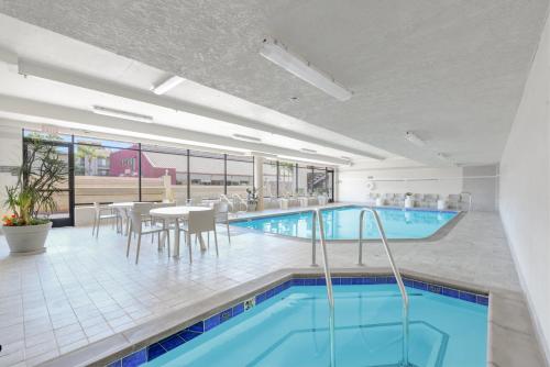 a pool in a hotel with a table and chairs and a dining room at Anaheim Desert Inn & Suites in Anaheim