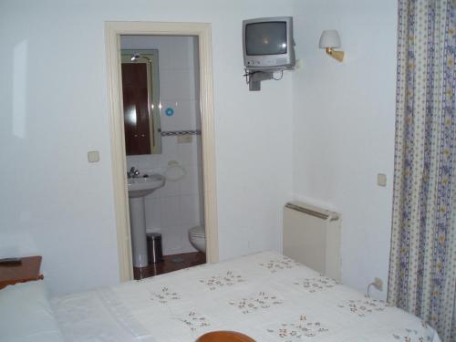 ein Schlafzimmer mit einem Bett und einem TV an der Wand in der Unterkunft Hostal Castilla in Madrid