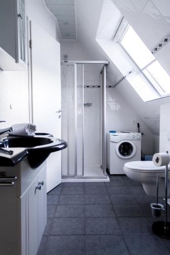 a bathroom with a toilet sink and a washing machine at Fewo Jutta Bönisch in List