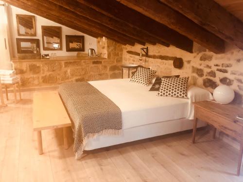 una camera con un grande letto in una parete in pietra di Lastias a Valderrobres