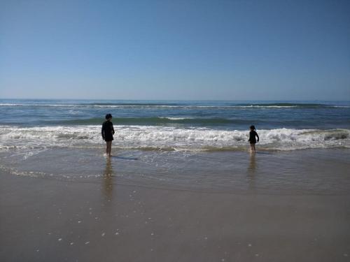 two people standing in the water on a beach at Meu pequeno paraíso in Itapoa