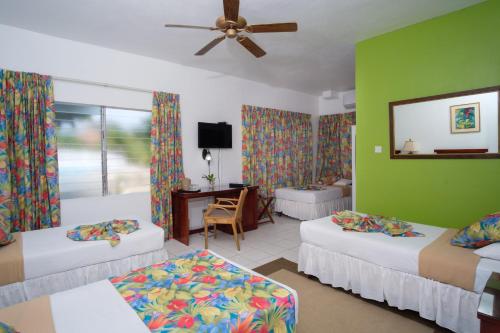 a hotel room with two beds and a television at Hibiscus Lodge Hotel in Ocho Rios
