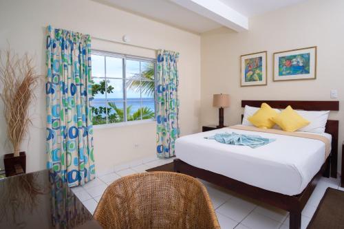 a bedroom with a bed and a window with the ocean at Hibiscus Lodge Hotel in Ocho Rios
