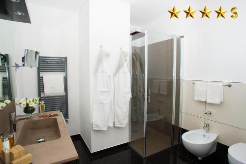 een badkamer met een douche, een wastafel en een toilet bij Hotel Rossini in Lignano Sabbiadoro