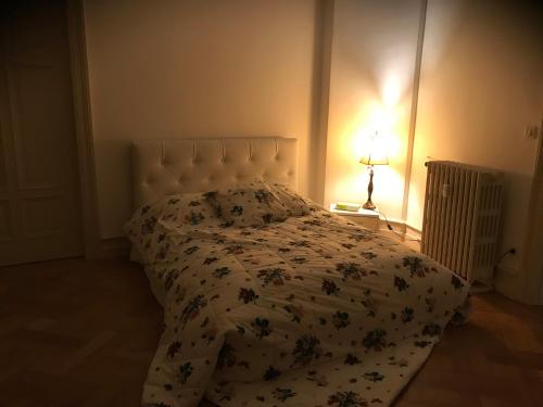 une chambre avec un lit avec un couvre-lit fleuri dans l'établissement 2 Boulevard de Nancy, à Strasbourg