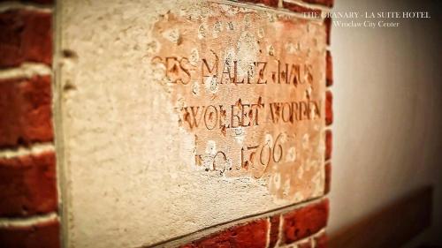 a brick wall with writing on the side of it at The Granary - La Suite Hotel in Wrocław