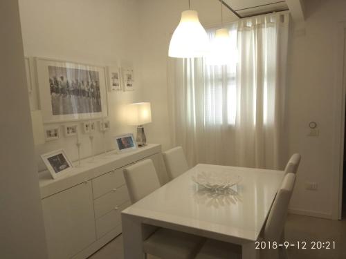 uma sala de jantar branca com uma mesa e cadeiras brancas em Milan center Luxury House em Sesto San Giovanni