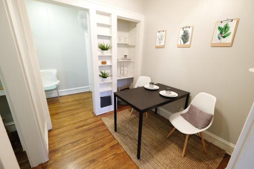 a dining room with a black table and two white chairs at The 1920s Mainstay Studio Flat on Lower Greenville in Dallas