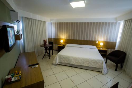 a hotel room with a bed and a desk at Garbos Trade Hotel in Mossoró