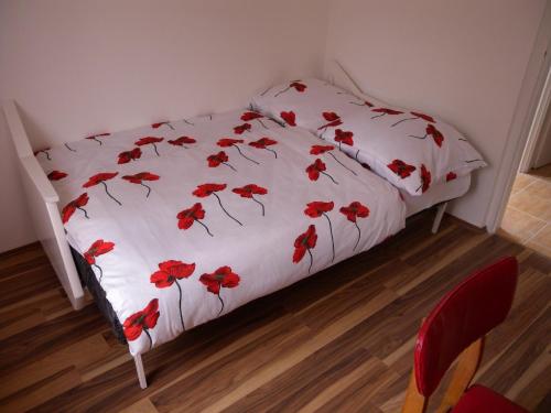 バラトンベレーニにあるApartment Balatonbereny 9のベッド(白い掛け布団、赤い花付)