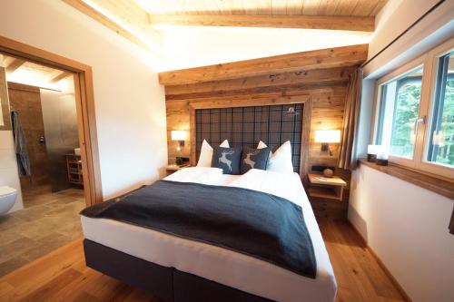 a bedroom with a large bed and a bathroom at Kaiserappartements-Marie in Ellmau