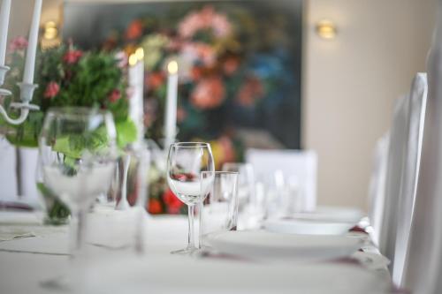 a table with wine glasses and plates and candles at Penzión ARTin in Nitra