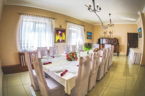 a dining room with a long table and chairs at Penzión ARTin in Nitra