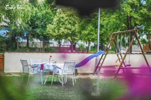 a table and chairs in a yard with a swing at Penzión ARTin in Nitra