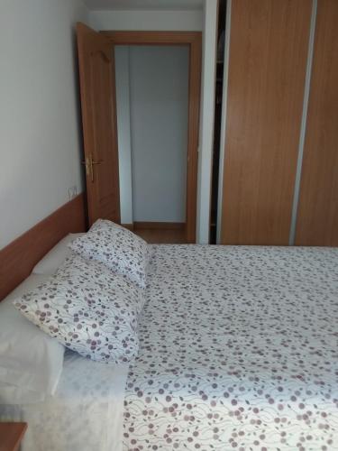un letto con due cuscini sopra di Apartamentos Vive Soria a Soria