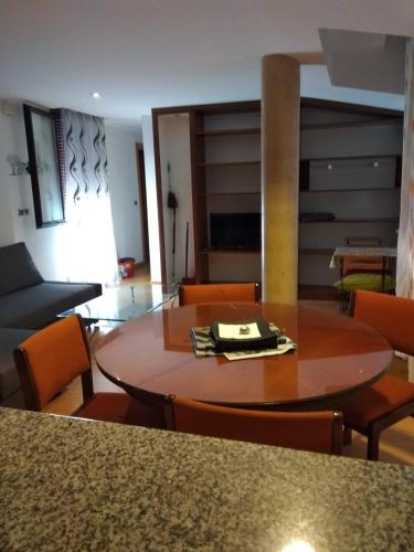 a dining room and living room with a table and chairs at Apartamentos Vive Soria in Soria