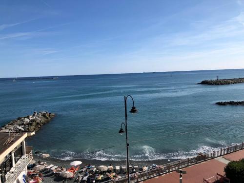 a view of a beach with a street light and the ocean at La Casetta di Dory sul Mare in Genova
