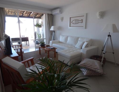 uma sala de estar com um sofá branco e uma mesa em Ocean Terraces Vila Gaivota I em Ferragudo