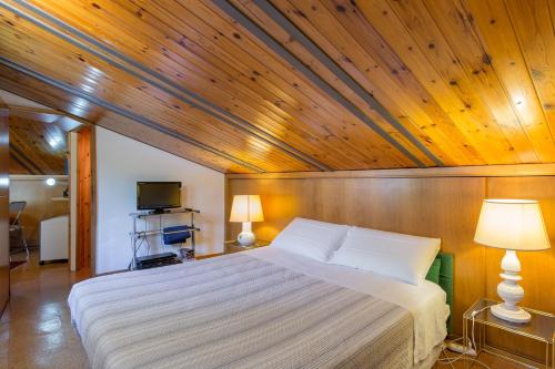ein Schlafzimmer mit einem großen Bett und einer Holzdecke in der Unterkunft Gheller Apartment in Verona