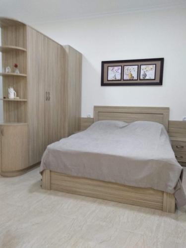 a bedroom with a bed and a wooden cabinet at Apart hotel Alex in Yerevan