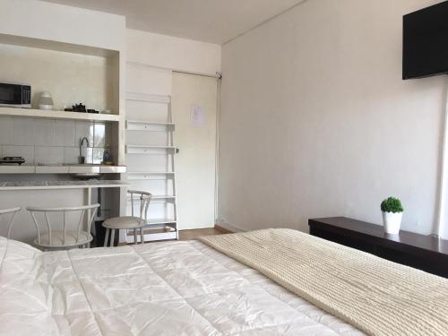 a bedroom with a bed and a desk and a kitchen at Lima Mini Aparts Monterrico - Cerca Embajada EEUU in Lima