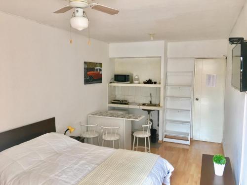 リマにあるLima Mini Aparts Monterrico - Cerca Embajada EEUUの小さなベッドルーム(ベッド1台付)、キッチンが備わります。
