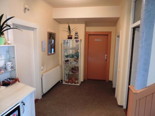 a hallway with a red door and a room at Penzion Pohoda Beroun in Beroun