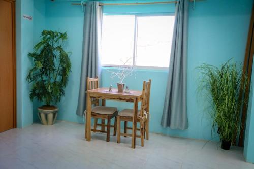 a dining room with a table and two chairs and a window at Casa del mar caribe in Isla Mujeres