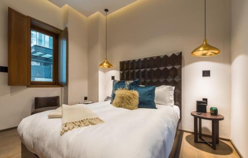 a bedroom with a large white bed with blue pillows at Casa Prim Hotel Boutique in Mexico City