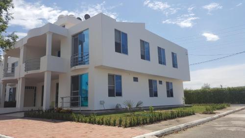 a white house with black windows on a street at Condominio Santa Hagia Sofia - Casa y 2 apartamentos in Flandes