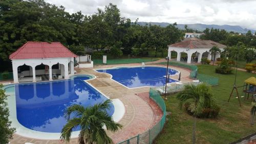 a large swimming pool with a gazebo and a house at Condominio Santa Hagia Sofia - Casa y 2 apartamentos in Flandes