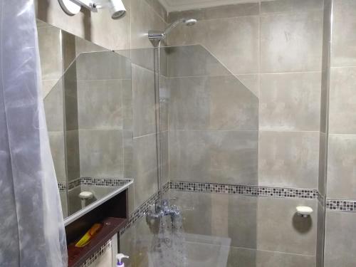 y baño con ducha y puerta de cristal. en Departamento Miralejos 9 en Villa Carlos Paz