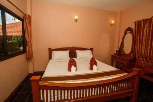 a bedroom with a bed with shoes on it at Noble Night Guesthouse in Kanchanaburi