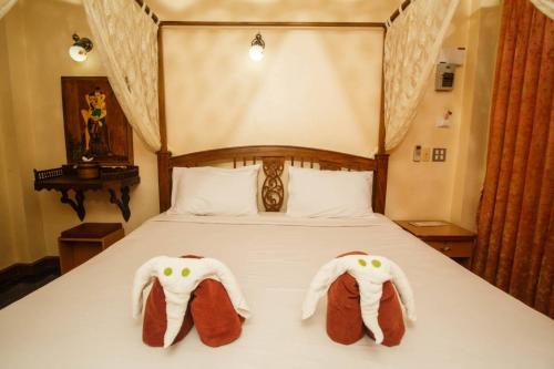 two towels in the shape of elephants are on a bed at Noble Night Guesthouse in Kanchanaburi