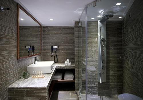 a bathroom with a sink and a shower at Art Mainalon Hotel in Vytina