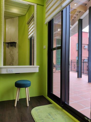 a stool in a room with a green wall at Teacher Cai Homeestay in Xiaoliuqiu